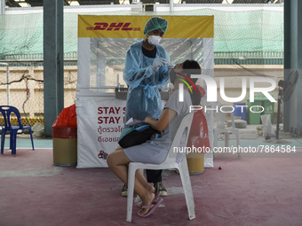 A health worker from Khlongtoey Deejung organisation takes a swab sample for a rapid antigen test, amid the coronavirus Omicron (COVID-19) p...