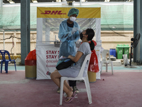 A health worker from Khlongtoey Deejung organisation takes a swab sample for a rapid antigen test, amid the coronavirus Omicron (COVID-19) p...