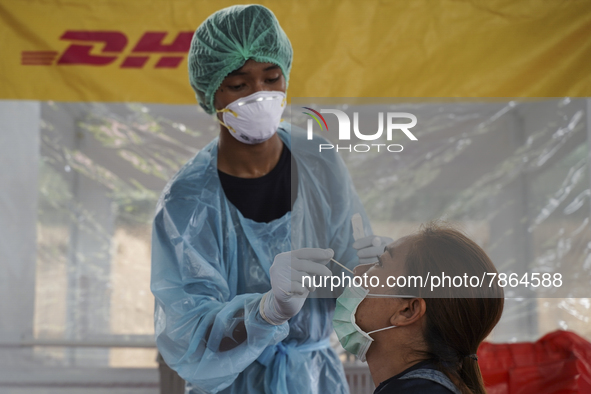 A health worker from Khlongtoey Deejung organisation takes a swab sample for a rapid antigen test, amid the coronavirus Omicron (COVID-19) p...