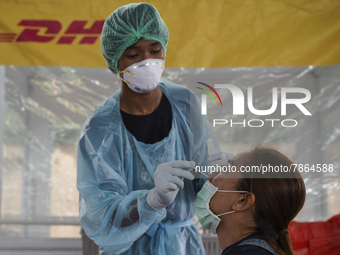 A health worker from Khlongtoey Deejung organisation takes a swab sample for a rapid antigen test, amid the coronavirus Omicron (COVID-19) p...