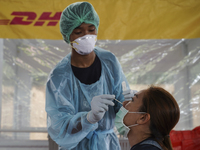 A health worker from Khlongtoey Deejung organisation takes a swab sample for a rapid antigen test, amid the coronavirus Omicron (COVID-19) p...