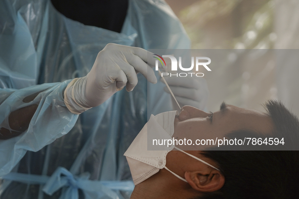 A health worker from Khlongtoey Deejung organisation takes a swab sample for a rapid antigen test, amid the coronavirus Omicron (COVID-19) p...