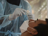 A health worker from Khlongtoey Deejung organisation takes a swab sample for a rapid antigen test, amid the coronavirus Omicron (COVID-19) p...