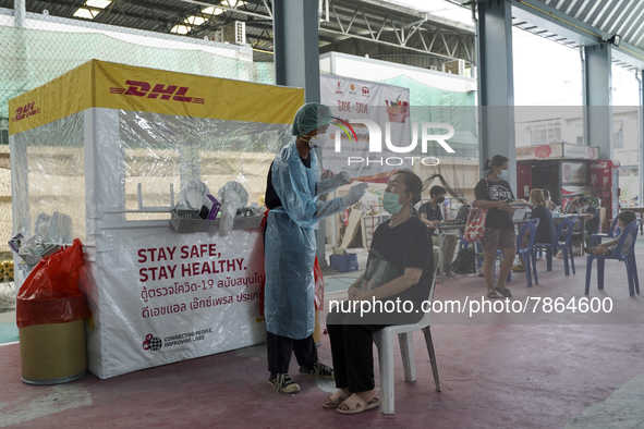 A health worker from Khlongtoey Deejung organisation takes a swab sample for a rapid antigen test, amid the coronavirus Omicron (COVID-19) p...