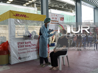 A health worker from Khlongtoey Deejung organisation takes a swab sample for a rapid antigen test, amid the coronavirus Omicron (COVID-19) p...