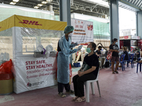 A health worker from Khlongtoey Deejung organisation takes a swab sample for a rapid antigen test, amid the coronavirus Omicron (COVID-19) p...