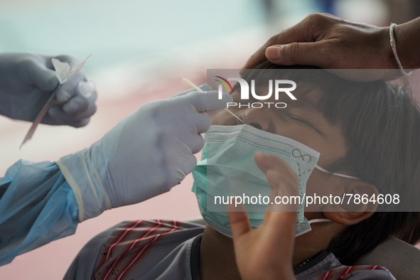 A health worker from Khlongtoey Deejung organisation takes a swab sample for a rapid antigen test, amid the coronavirus Omicron (COVID-19) p...