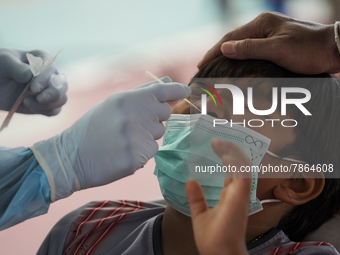 A health worker from Khlongtoey Deejung organisation takes a swab sample for a rapid antigen test, amid the coronavirus Omicron (COVID-19) p...