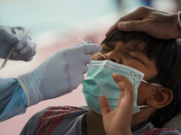 A health worker from Khlongtoey Deejung organisation takes a swab sample for a rapid antigen test, amid the coronavirus Omicron (COVID-19) p...