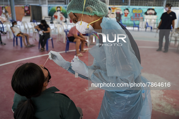 A health worker from Khlongtoey Deejung organisation takes a swab sample for a rapid antigen test, amid the coronavirus Omicron (COVID-19) p...