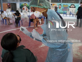 A health worker from Khlongtoey Deejung organisation takes a swab sample for a rapid antigen test, amid the coronavirus Omicron (COVID-19) p...