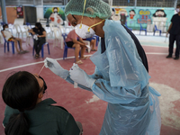 A health worker from Khlongtoey Deejung organisation takes a swab sample for a rapid antigen test, amid the coronavirus Omicron (COVID-19) p...