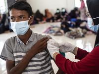 Rohingya refugees receives a shot of the Sinovac COVID-19 vaccine at temporary shelter in Alue Buya Pasie village after strandet on a beach...