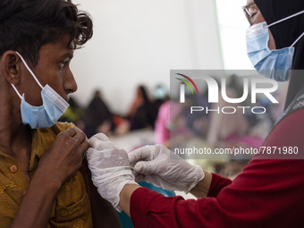 Rohingya refugees receives a shot of the Sinovac COVID-19 vaccine at temporary shelter in Alue Buya Pasie village after strandet on a beach...