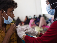 Rohingya refugees receives a shot of the Sinovac COVID-19 vaccine at temporary shelter in Alue Buya Pasie village after strandet on a beach...