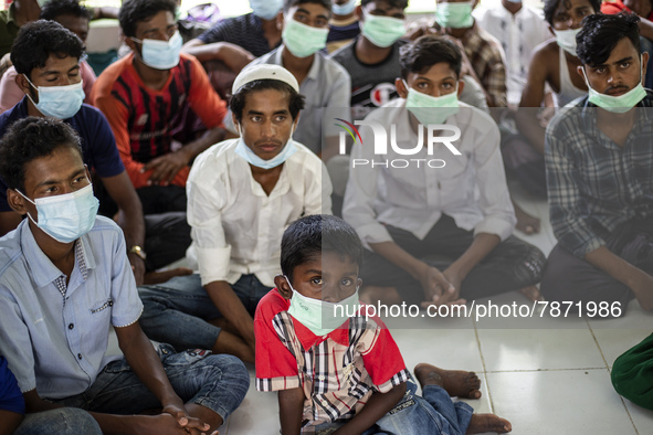 Rohingya refugees wears face mask sit at temporary shelter in Alue Buya Pasie village after strandet on a beach in Bireuen regency, Aceh pro...