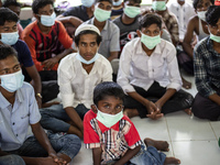 Rohingya refugees wears face mask sit at temporary shelter in Alue Buya Pasie village after strandet on a beach in Bireuen regency, Aceh pro...