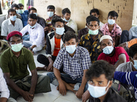 Rohingya refugees wears face mask sit at temporary shelter in Alue Buya Pasie village after strandet on a beach in Bireuen regency, Aceh pro...