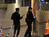 Policemen remove banners warning against gathering placed in a subterranean tunnel where Filipina domestic helpers have the habit of sitting...