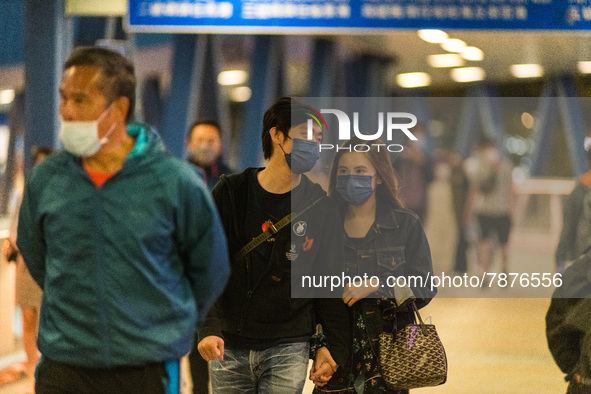 Masked people walk on an elevated passageway in Central Hong Kong, in Hong Kong, China, on March 6, 2022.  