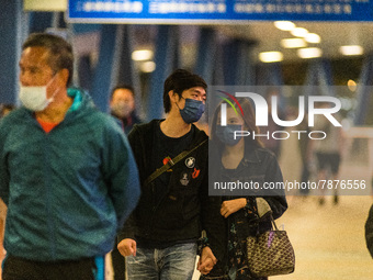 Masked people walk on an elevated passageway in Central Hong Kong, in Hong Kong, China, on March 6, 2022.  (