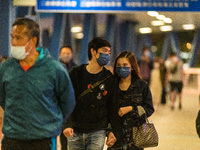 Masked people walk on an elevated passageway in Central Hong Kong, in Hong Kong, China, on March 6, 2022.  (