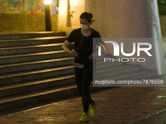 A masked jogger runs in front of the Central piers, in Hong Kong. Even strenuous physical activity without a mask is now punished with a 5,0...