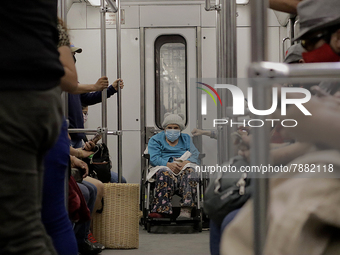 An elderly woman in a wheelchair inside a metro carriage in Mexico City during the change to green epidemiological traffic light after recor...