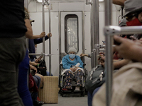 An elderly woman in a wheelchair inside a metro carriage in Mexico City during the change to green epidemiological traffic light after recor...