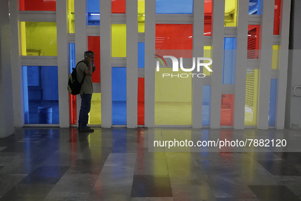 A person in front of a stained glass window in a Mexico City metro station during the change to green epidemiological traffic light after re...