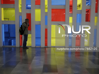 A person in front of a stained glass window in a Mexico City metro station during the change to green epidemiological traffic light after re...