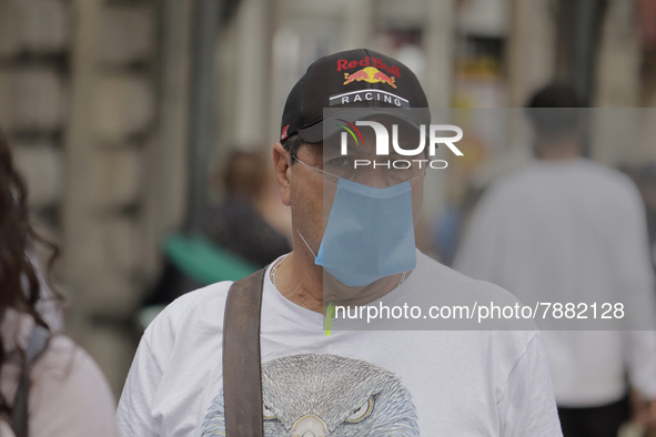 A pedestrian carries a mask in the Zócalo of Mexico City during the change to green epidemiological traffic light after registering a decrea...