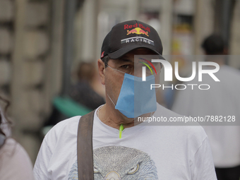 A pedestrian carries a mask in the Zócalo of Mexico City during the change to green epidemiological traffic light after registering a decrea...