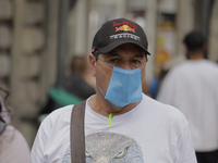 A pedestrian carries a mask in the Zócalo of Mexico City during the change to green epidemiological traffic light after registering a decrea...