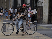 A couple on a bicycle in Mexico City's Zócalo during the change to green epidemiological traffic light after recording a decrease in hospita...