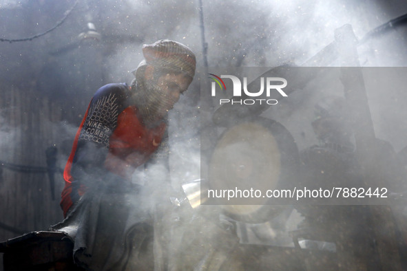 Worker works in dust environment inside in a utensil factory while sunrays enter through the rooftop in Dhaka, Bangladesh on March 08, 2022....