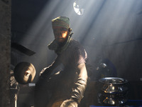 Worker works in dust environment inside in a utensil factory while sunrays enter through the rooftop in Dhaka, Bangladesh on March 08, 2022....