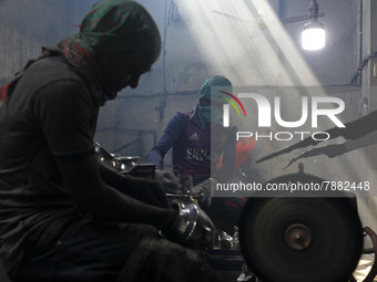 Worker works in dust environment inside in a utensil factory while sunrays enter through the rooftop in Dhaka, Bangladesh on March 08, 2022....