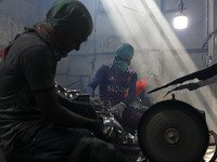 Worker works in dust environment inside in a utensil factory while sunrays enter through the rooftop in Dhaka, Bangladesh on March 08, 2022....