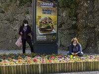 People wearing protective masks are seen picking some flowers around a street in Sintra. 28 February 2022. According to the General Health D...