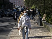 A woman wearing a protective mask is seen walking near a monument in the surroundings of a street in Sintra. 28 February 2022. According to...