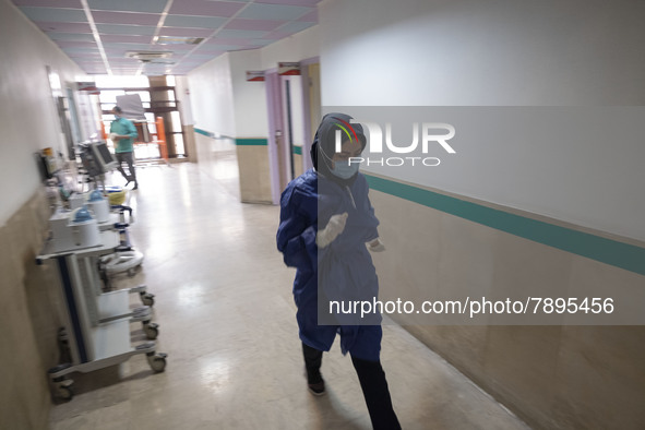 An Iranian nurse wearing a protective suit walks along a corridor at a COVID-19 ward in a children hospital in the holy city of Qom 145Km (9...