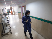 An Iranian nurse wearing a protective suit walks along a corridor at a COVID-19 ward in a children hospital in the holy city of Qom 145Km (9...