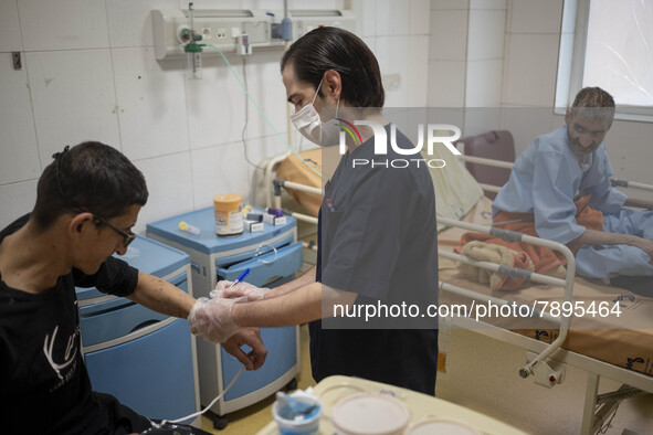 An Iranian nurse wearing a protective suit attends to a patient at a COVID-19 ward in a hospital in the holy city of Qom 145Km (90 miles) so...