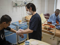 An Iranian nurse wearing a protective suit attends to a patient at a COVID-19 ward in a hospital in the holy city of Qom 145Km (90 miles) so...