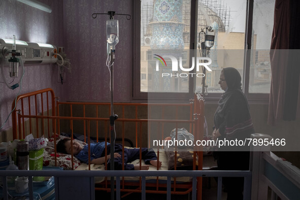 An Iranian mother stands next to her 9-year-old son with autism who is infected by COVID-19 as well, at a new coronavirus disease ward in a...