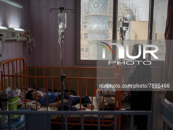 An Iranian mother stands next to her 9-year-old son with autism who is infected by COVID-19 as well, at a new coronavirus disease ward in a...