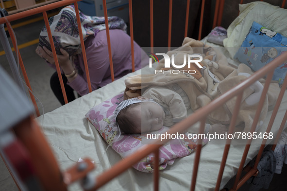 An Afghan mother sits next to her 5-mounth-old kid who is infected by COVID-19, at a COVID-19 ward in a children hospital in the holy city o...