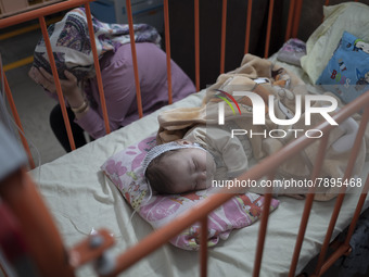 An Afghan mother sits next to her 5-mounth-old kid who is infected by COVID-19, at a COVID-19 ward in a children hospital in the holy city o...