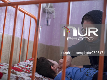 An Iranian mother takes care of her 9-year-old son with autism who is infected by COVID-19 as well, at a new coronavirus disease ward in a c...